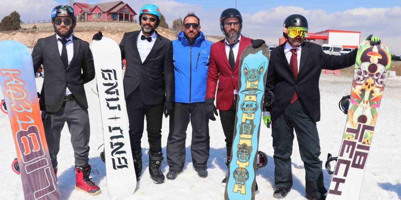 Kayak sezonunu takım elbiseyle snowboard yaparak uğurladılar