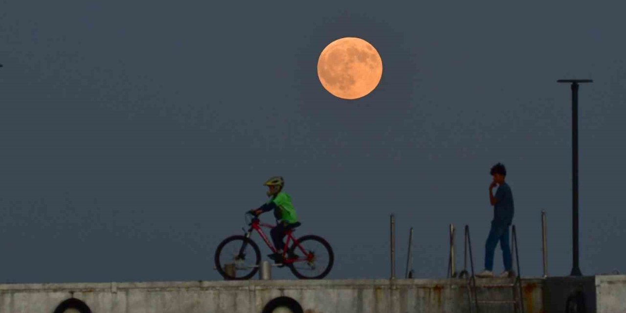 Dolunay ile insanların siluetleri aynı karede