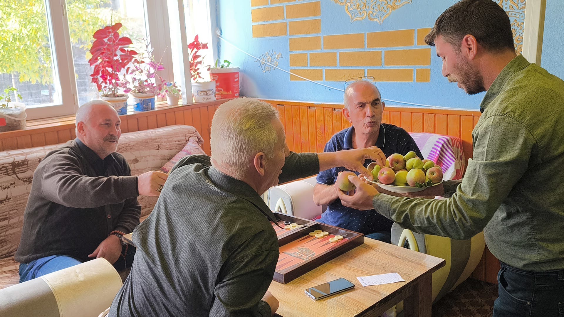 Kafenin ortasındaki ağaçların meyvesini ikram etti