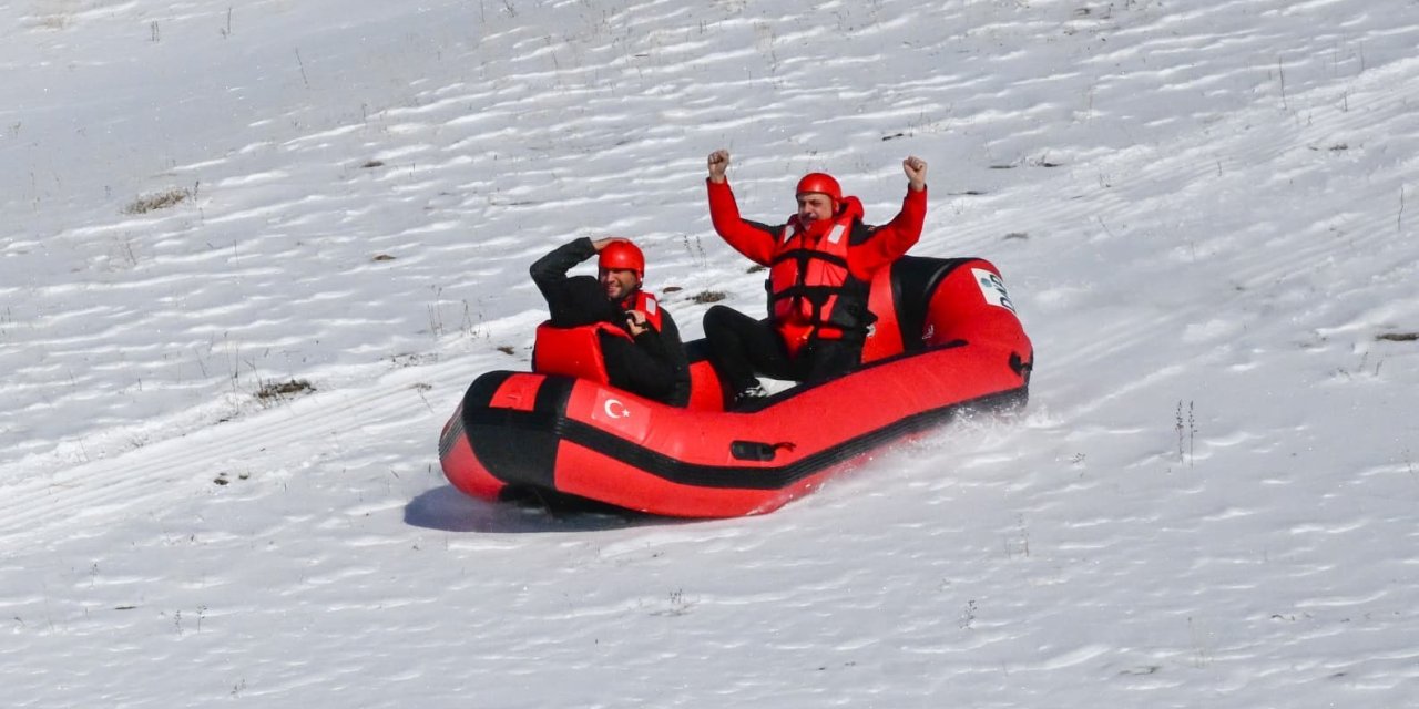 Karla kaplı dağdan donmuş gölete botla kaydılar